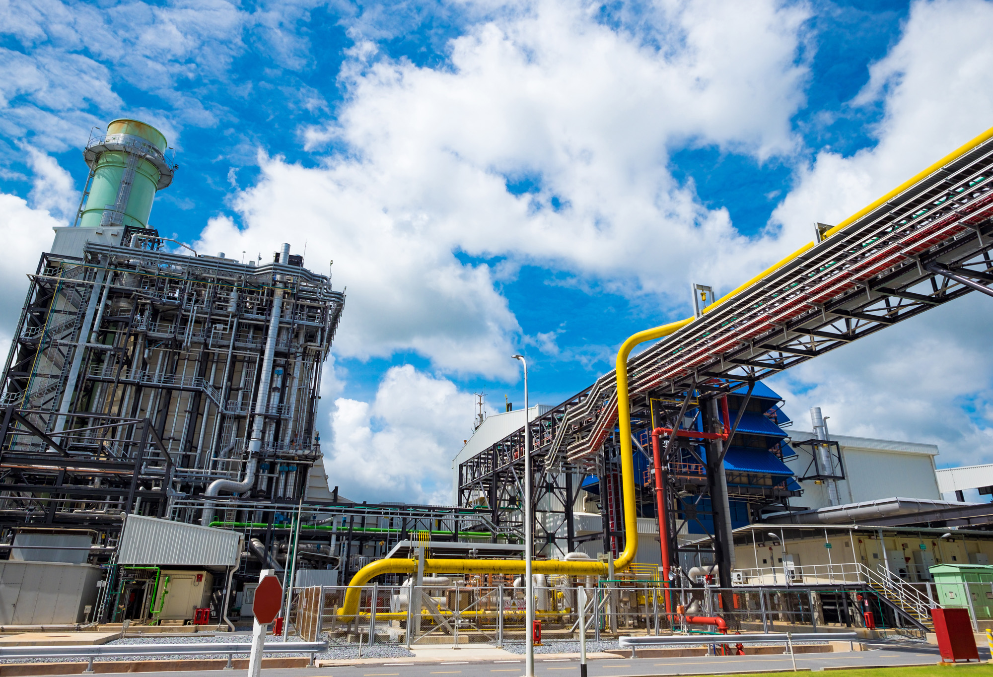 Combined Cycle Plant with red and yellow piping and blue sky